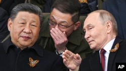 Ruski predsjednik Vladimir Putin i kineski lider Xi Jinping razgovaraju za vrijeme vojne parade povodom Dana pobjede, Moskva, maj 2025.