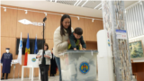 Moldova, A mother holds her child over a ballot box, Moldova election 2025
