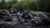 Құлаған малайзиялық Boeing 777 жолаушылар ұшағының бөлшектерін суретке түсіріп тұрған журналист. Грабово селосы, Донецк облысы, 18 шілде 2014 жыл.