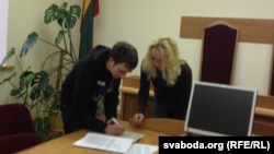 Сьцяпан Захарчанка падпісвае паперы пасьля суду