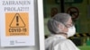 Croatia - A medical staff member wearing a protective face mask stands by a placard reading "No entry" in the Dubrava hospital receiving patients infected with the coronavirus Covid-19, in Zagreb on March 4, 2021.