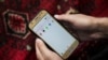 Čovek drži mobilni telefon u Avganistanu, 30. septembar 2025.