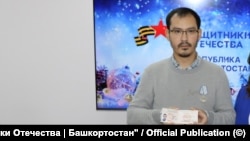 Тимур Пралиев с удостоверением ветерана боевых действий.