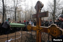 Донецкідегі шабуылдан қаза тапқан екі баланың жерлеуі.