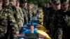 Украинаның шығысындағы қарулы қақтығыста қаза тапқан адамдарды жерлеу сәті. Запорожье, 1 қазан 2014 жыл.