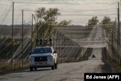 Vozilo opremljeno opremom za ometanje signala vozi se cestom prekrivenom mrežama protiv dronova u istočnoj Ukrajini 2. 10. 2025.