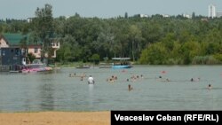 Oameni se scaldă în unul din lacurile din Chișinău, iulie 2023.